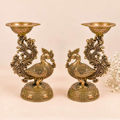 Pair of handcrafted brass peacock diya lamps from Kaari Tales, traditional oil lamps for puja, festive decor, and gifting.
