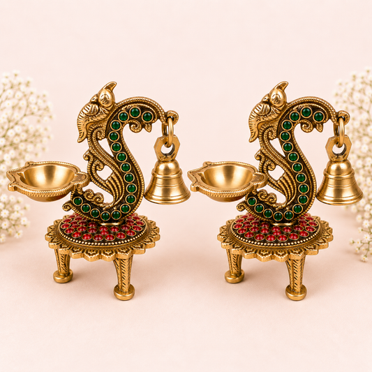 Pair of handcrafted brass diya lamps featuring peacock and hamsa motifs, traditional Indian oil lamps for puja and festive decor